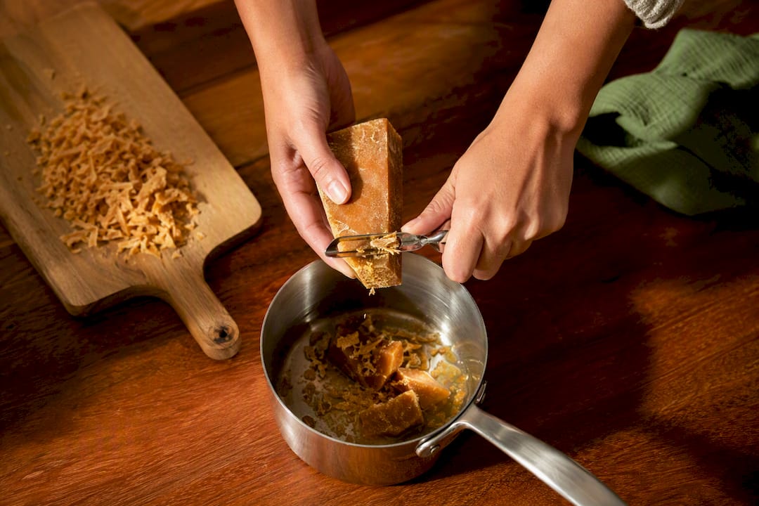 Hands preparing panela in three forms