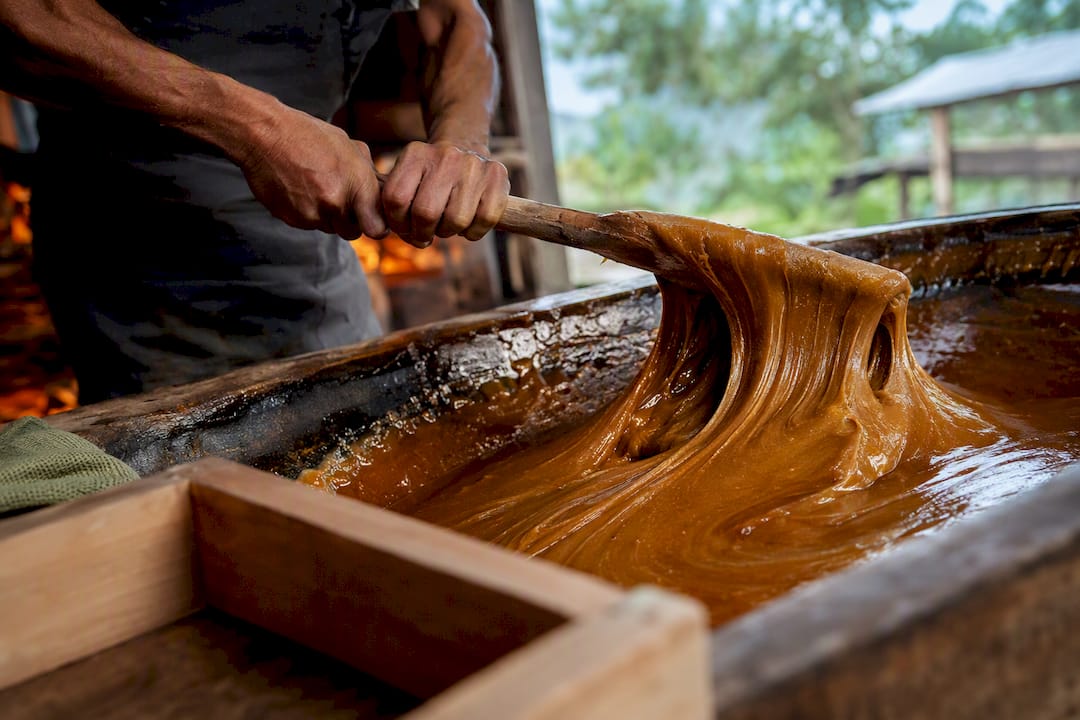 Hands beating warm panela syrup